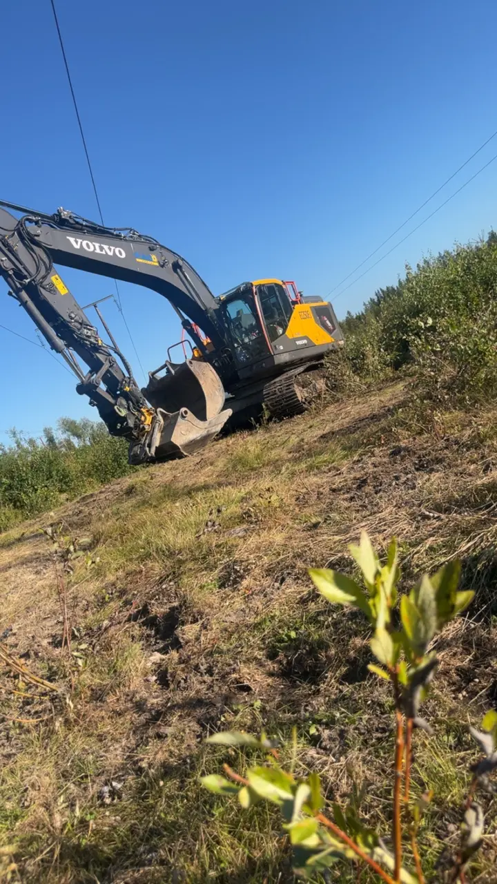 Eriks Volvo-grävmaskin arbetar i en sluttning.